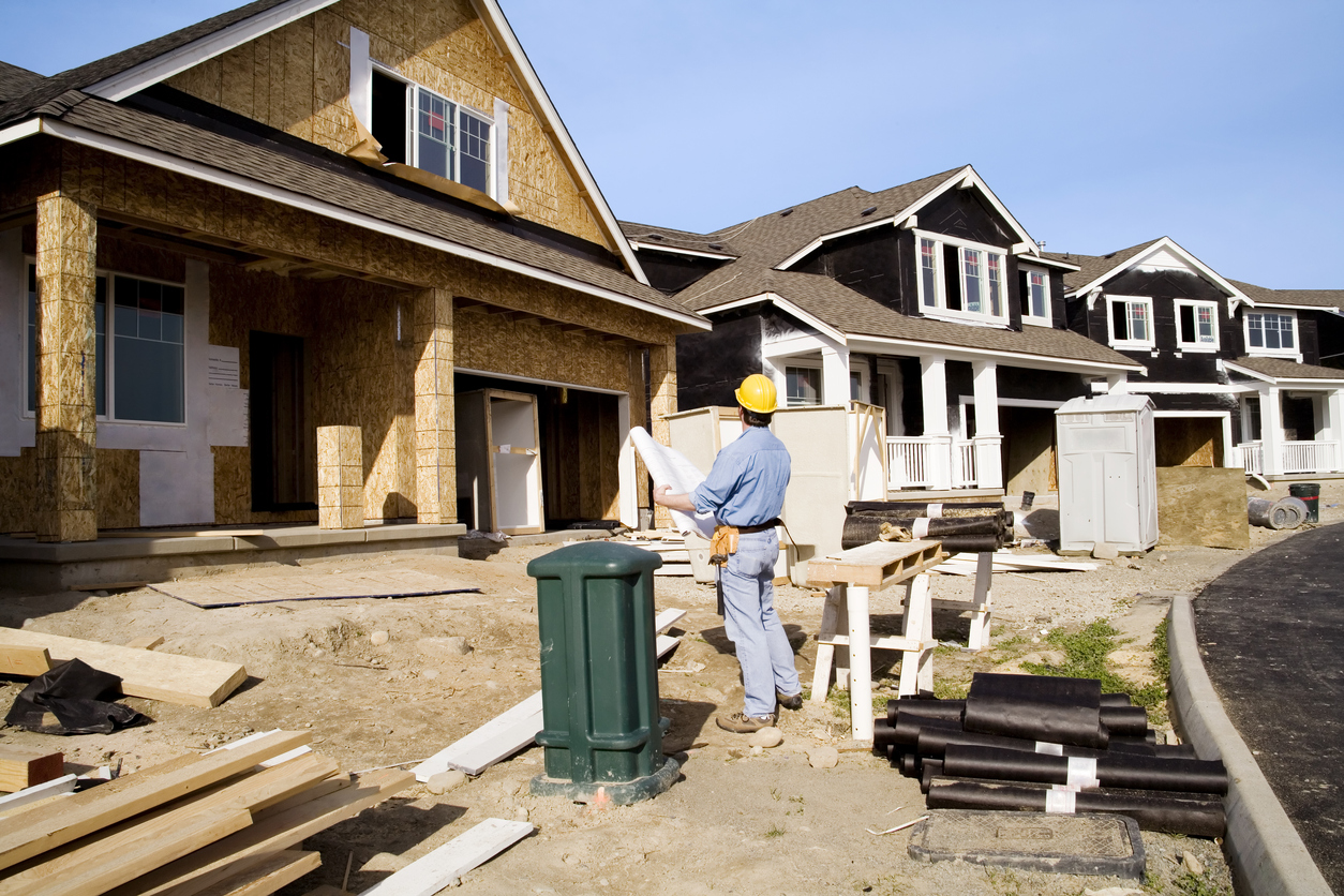 worker checking the blueprint of the house