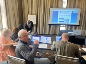 people attending the conference and taking notes